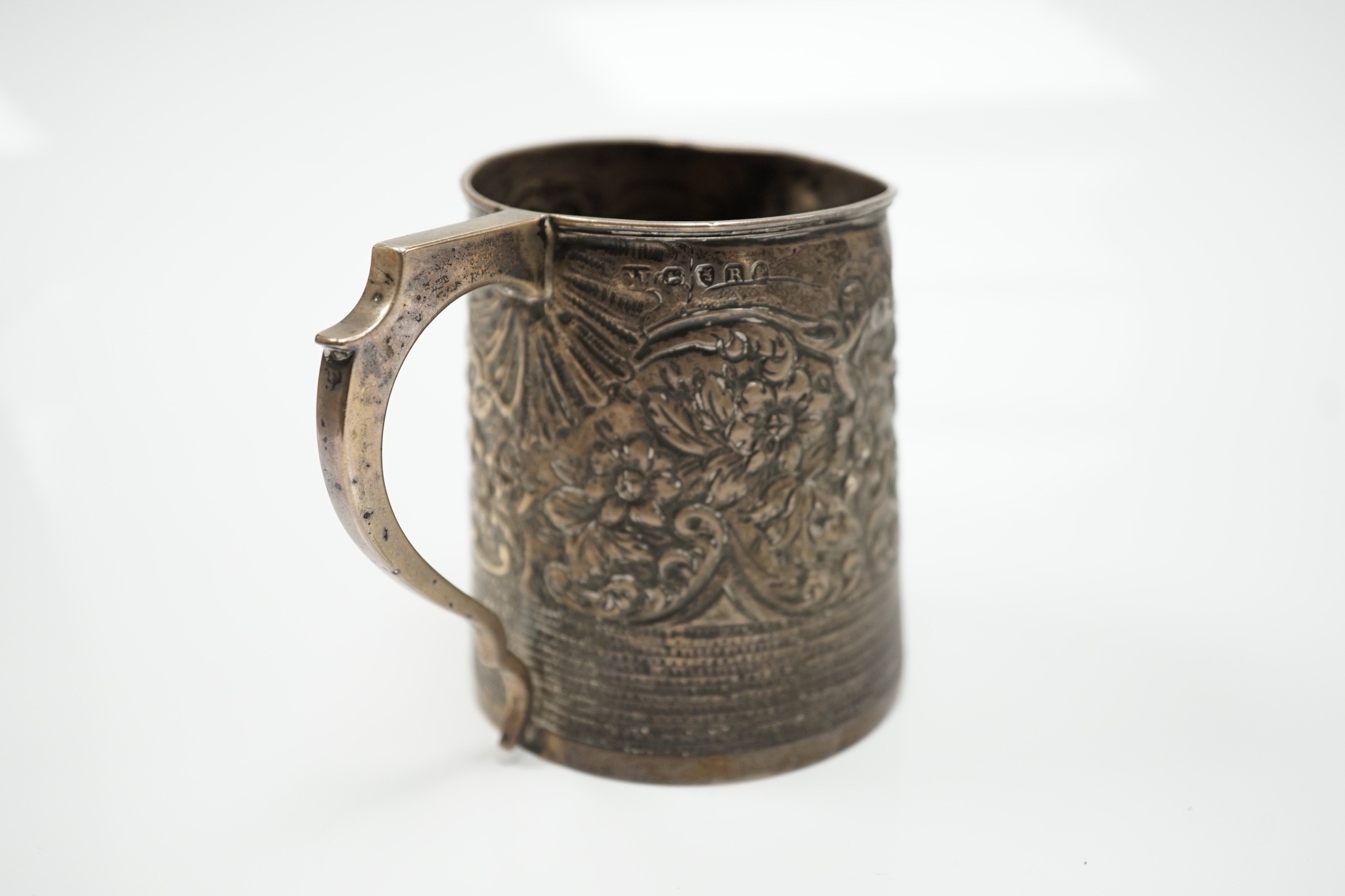 A George III silver mug, with later embossed decoration (af.), Charles Hougham?, London, 1812, height 81mm.